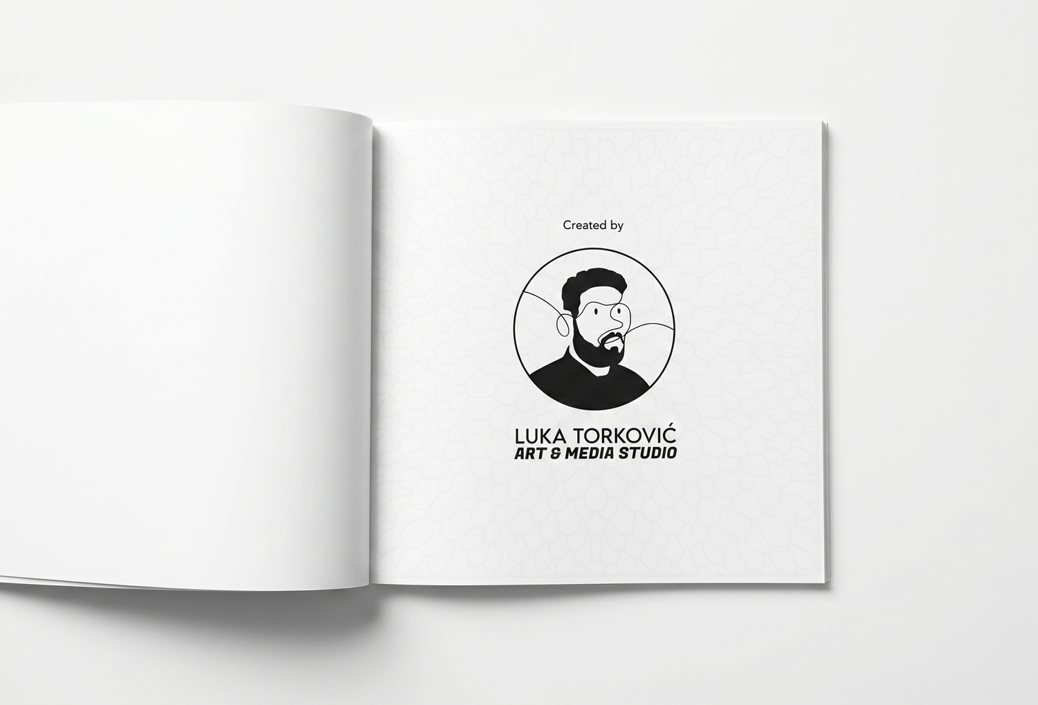 An open book on a white surface shows "Created by" and a circular logo of a bearded man with glasses. Below the circle is the text "LUKA TORKOVIĆ ART & MEDIA STUDIO" in all caps.