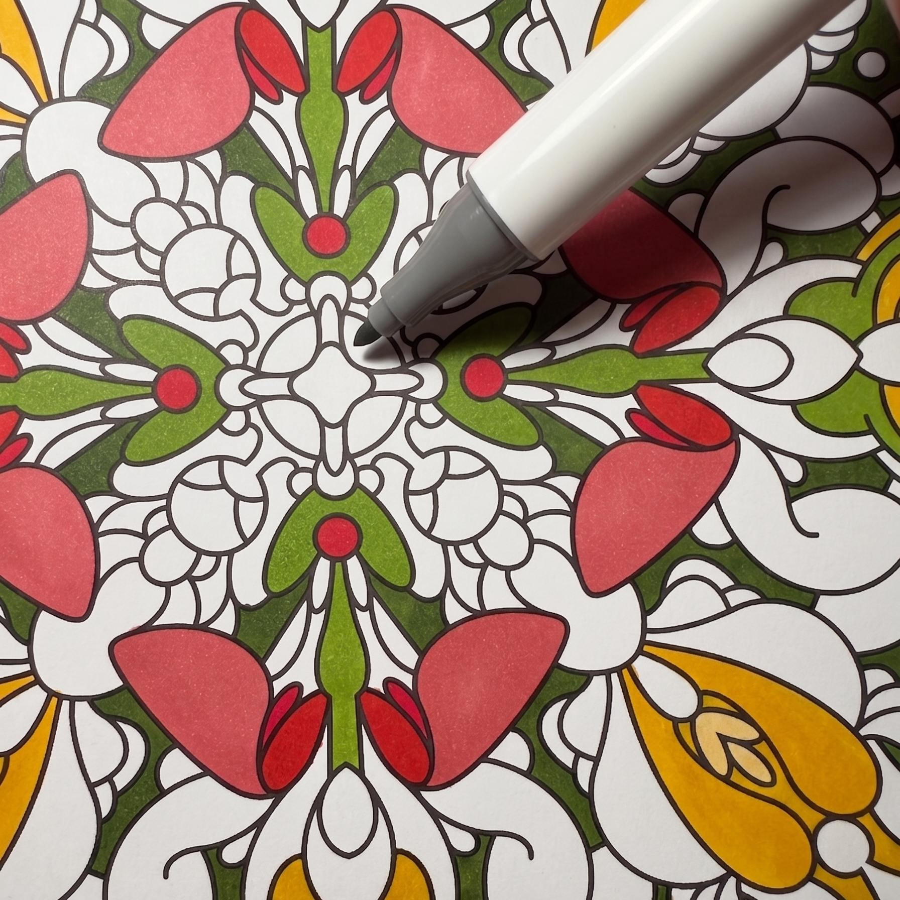 Fine detail macro shot of an alcohol-based marker coloring a vibrant flower pattern on smooth 120g fine paper.